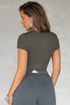 Back view of model posing in the form fitting mineral rib Crewneck Tee with a banded crew neckline and banding at the sleeves
