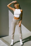 Full body front view of model posing in the tapered sand french terry Empire Jogger with side pockets and an elastic waistband and ankle cuffs