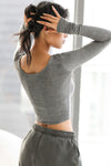 Back view of model posing in the fitted soft ash grey Scoop Neck Long Sleeve top with a deep scoop neckline and fitted sleeves
