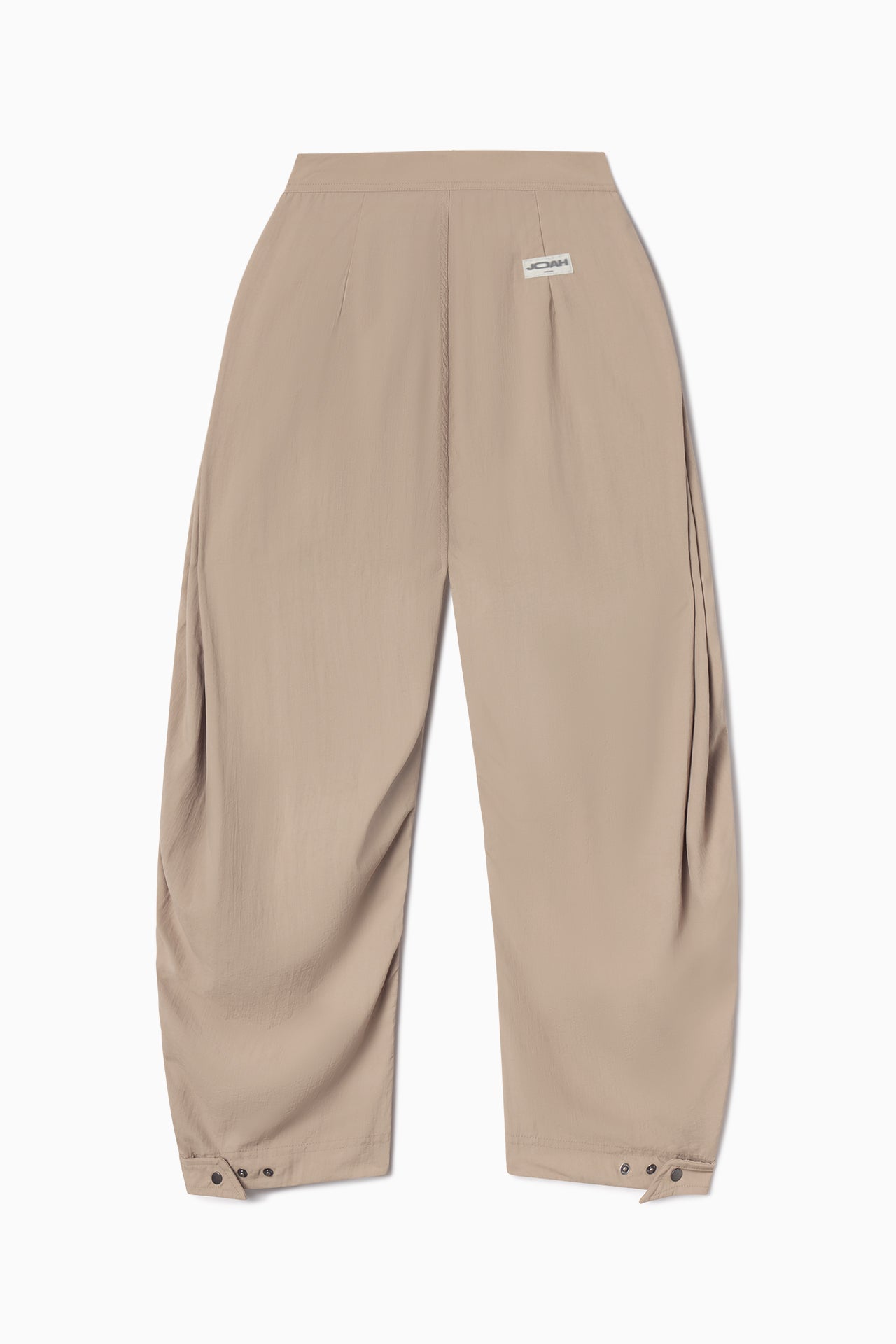 Back flat lay view of the oversized, horseshoe-style fawn nylon Barrel Pant with side pockets, zip fly, pleated sides, adjustable snap closures at the ankle and a JOAH BROWN logo on the back below the waistline.