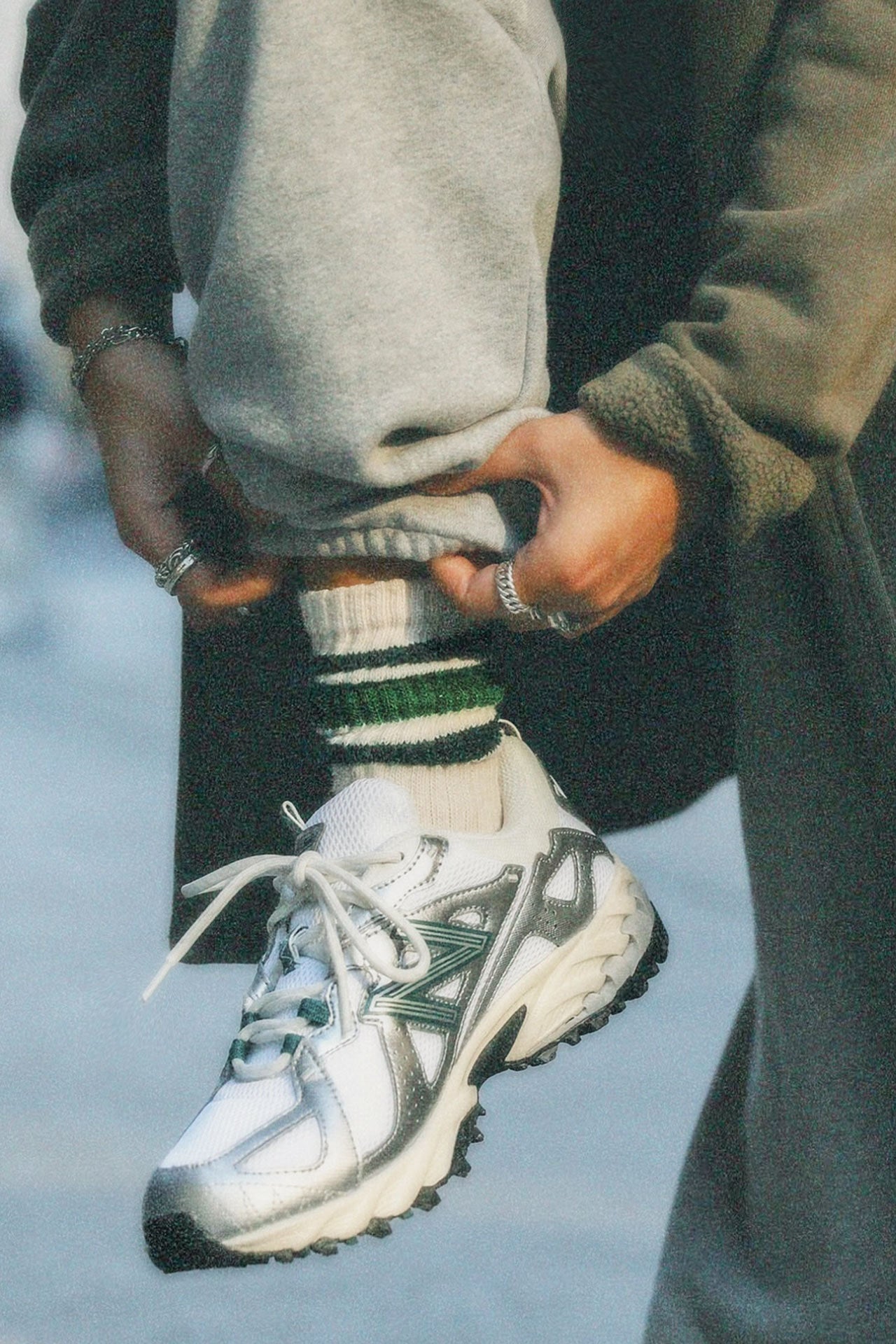 Close up front view of model adjusting the crew style ribbed soft forest green Classic Stripe Sock