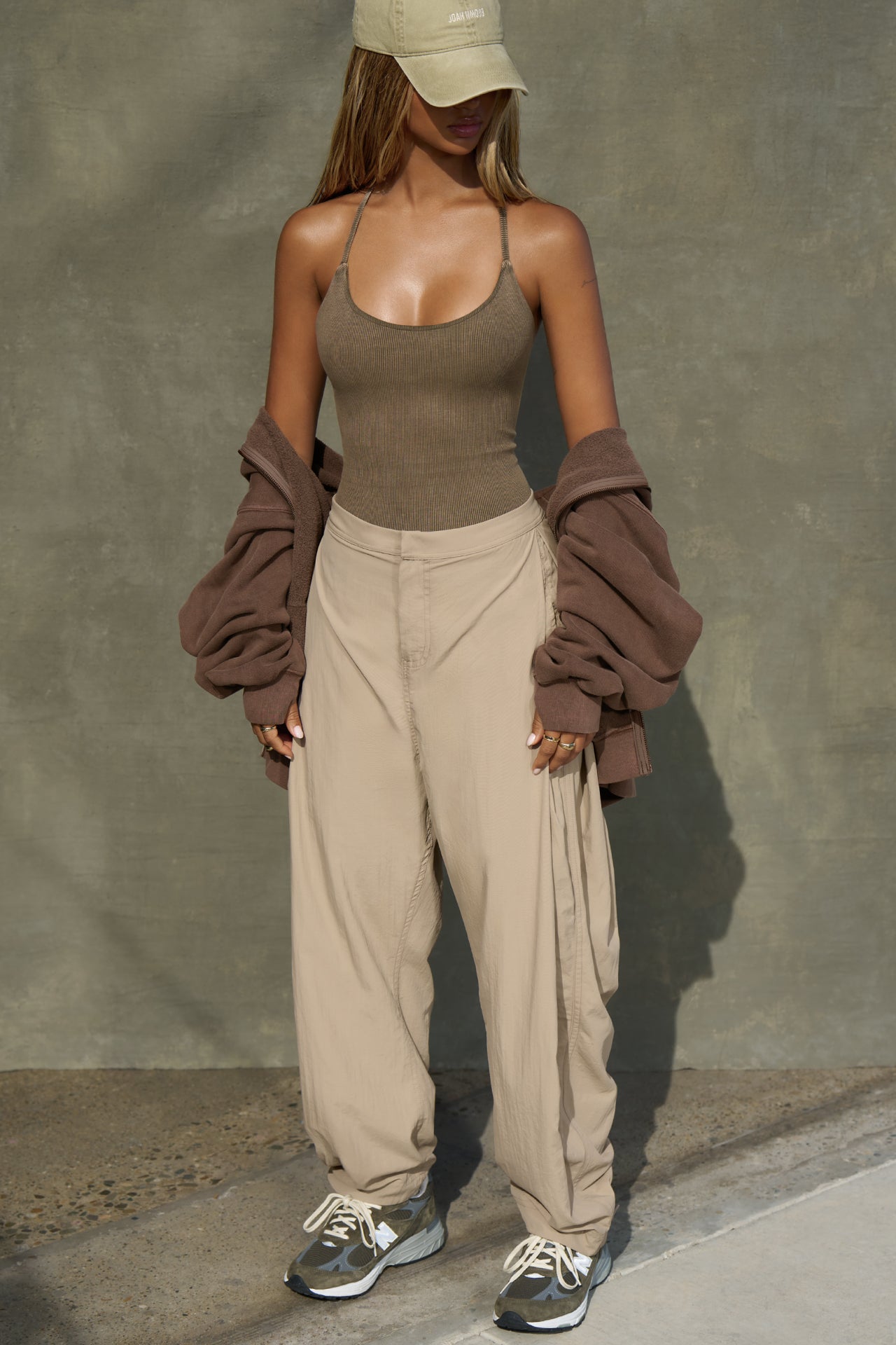 Full body front view of model posing in the fitted sepia washed rib Cross Back Cami with a scoop neckline and thin adjustable straps that criss cross in the back