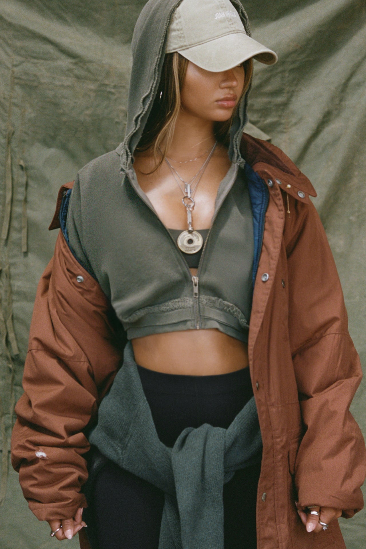 Front view of model posing in the loose-fit cropped washed sage french terry Deconstructed Crop Zip Hoodie with exposed seams and a JOAH BROWN logo patch on the sleeve