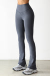 Front view of model from the waist down posing in the full length bootcut sueded navy Second Skin Bootcut Legging with a wide v-shaped waistband and split detail at the leg opening