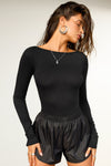 Front view of model posing in the fitted, light weight black modal Boatneck Long Sleeve with a boat neckline