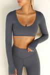 Front view of model posing the ultra cropped sueded navy Crop V Neck Long Sleeve top with with thumbholes