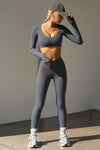 Full body front view of model posing the ultra cropped sueded navy Crop V Neck Long Sleeve top with with thumbholes
