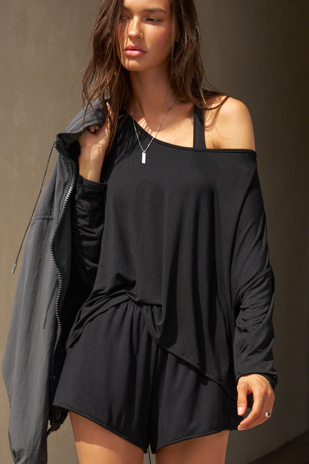 Front view of model posing in the relaxed-fit black modal Easy Short with an elastic waistband, side pockets and subtle pleating for added shape and dimension