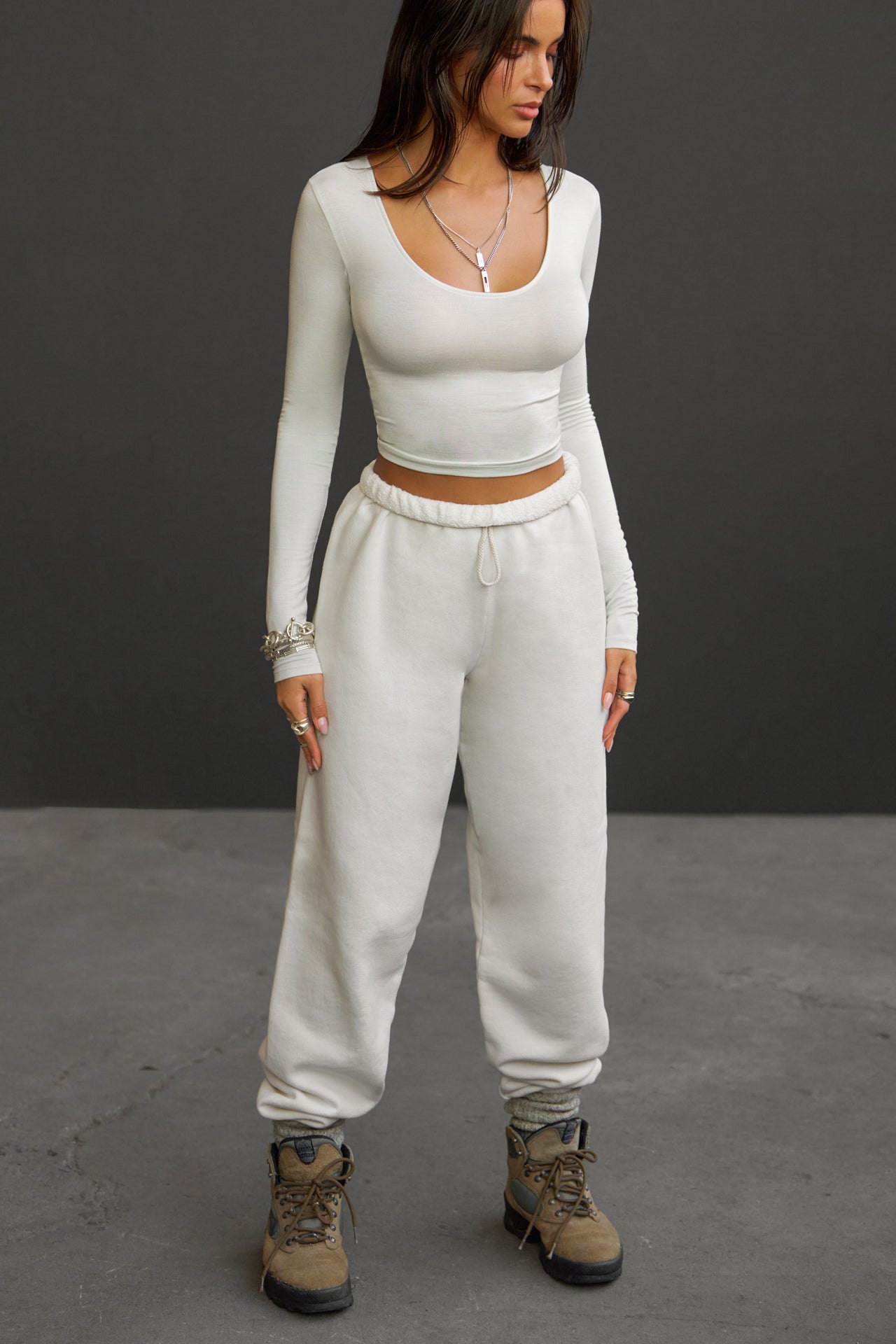 Full body front view of model posing in the oversized loose fit off white french terry Oversized Jogger with an elastic waistband and ankle cuffs