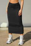 Front view of model from the waist down posing in the fitted black model Foldover Maxi Skirt with an adjustable fold over waistband