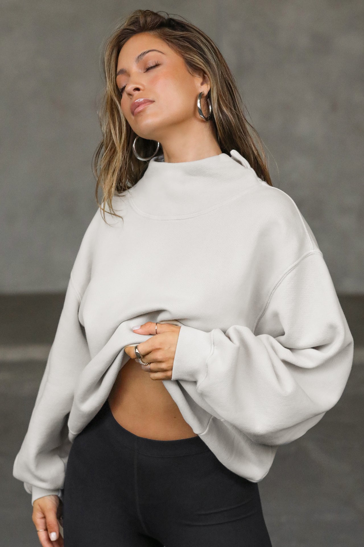 Front view of model posing in the comfortable sahara french terry Turtleneck Sweatshirt pullover with a side split in the collar and a slightly oversized fit