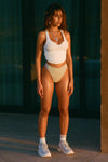 Full body front view of model posing in the fitted, full length bone flexrib Henley Tank with a notched henley neckline