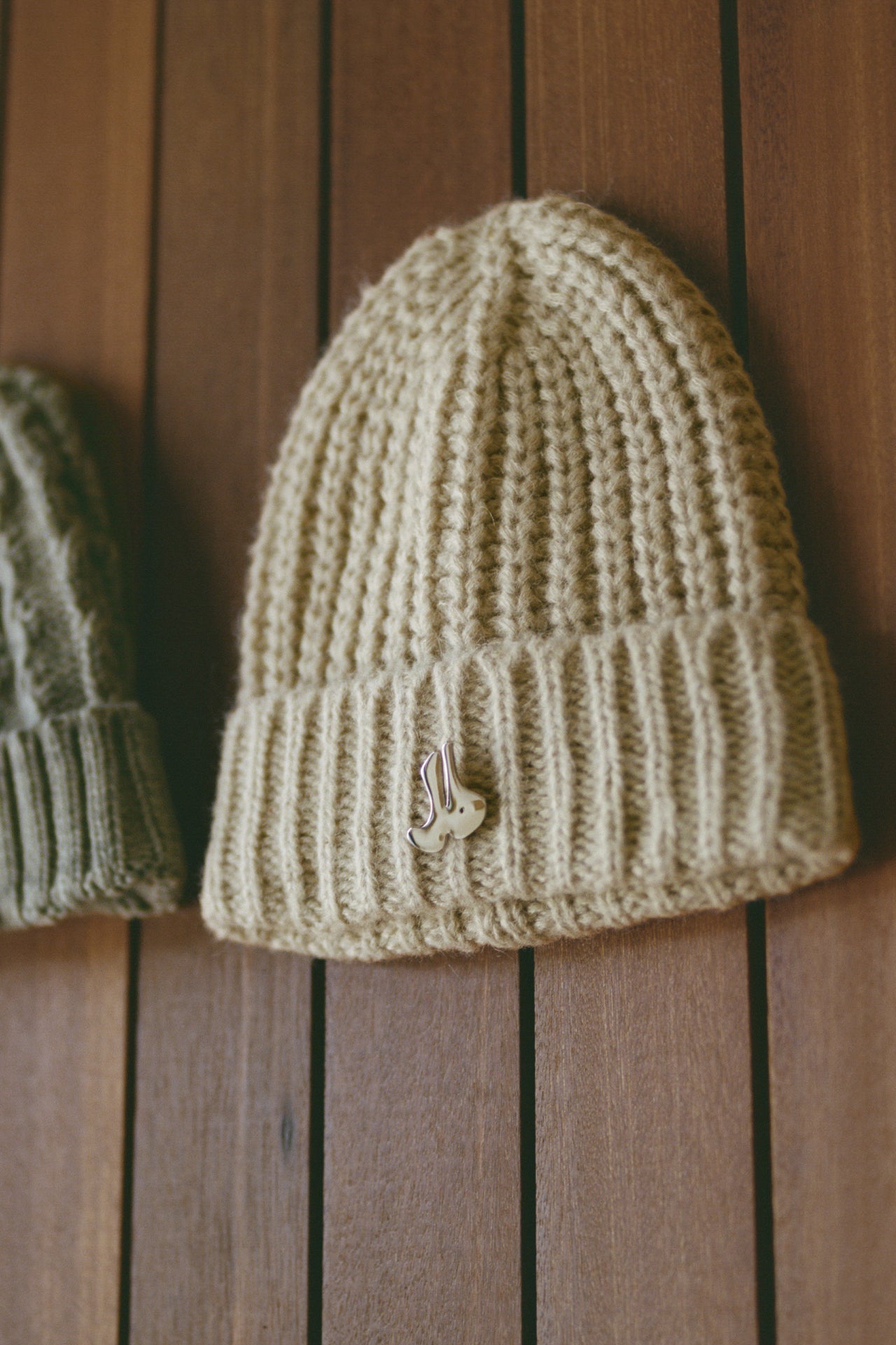 Front view of the soft and warm oat Knit Beanie that has a removable custom JOAH BROWN pin.