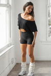 Full body front view of model posing in the cropped, loose fitting black model Slouchy Crop Tee with a wide scoop neckline