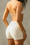 Back view of model posing in the fitted, soft natural luxe knit Foldover Short with a foldover waist band that can be worn high, low or mid-rise