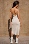 Back view of model posing the the midi length dune rib V Neck Dress with a semi-relaxed fit, low scoop back, side slit and thin adjustable straps