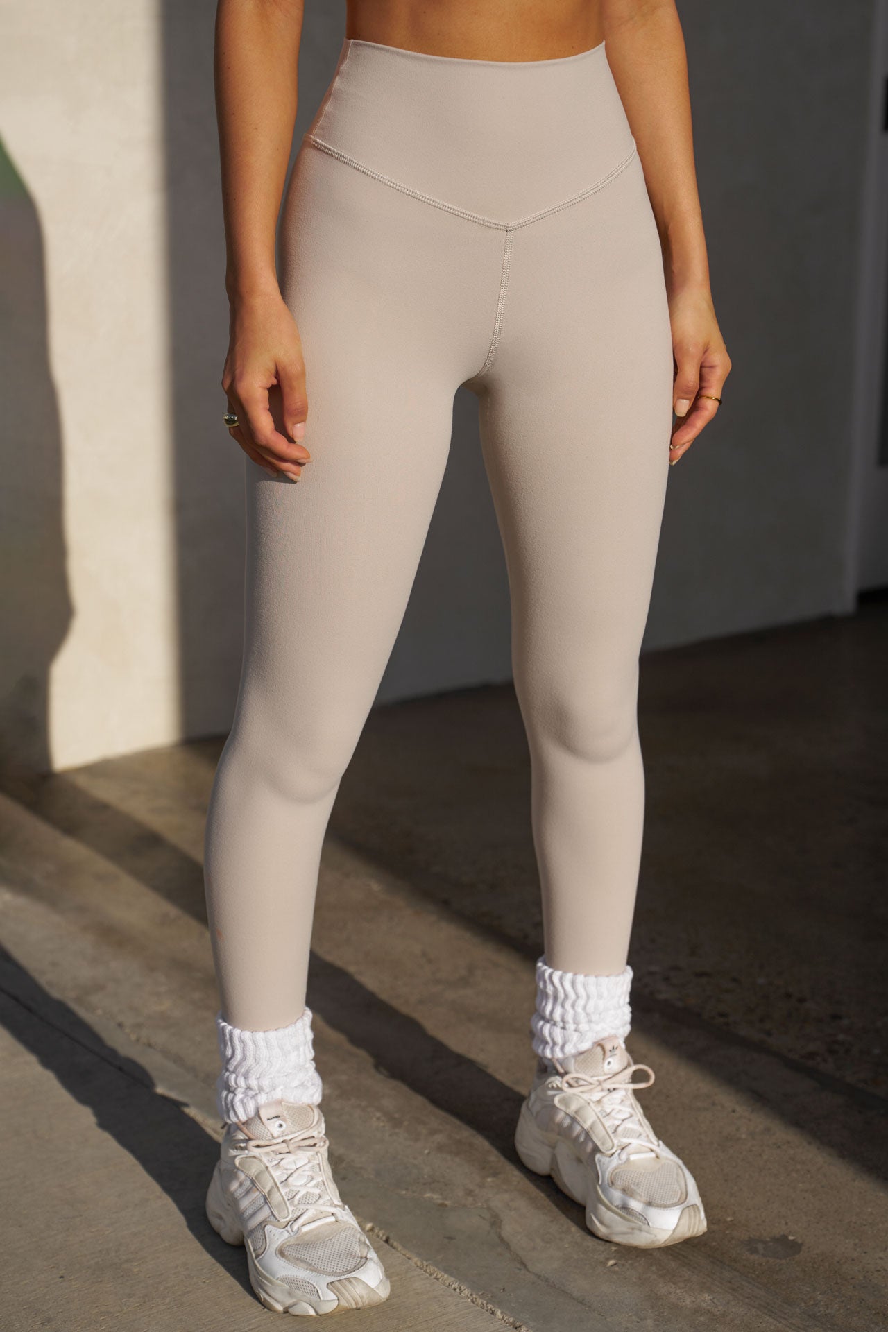 Front view of model from the waist down posing in the full length and high-waisted sueded yuma Second Skin Legging with a wide, v-shaped waistband