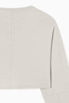 Close up detail back flat lay view of the cropped relaxed fit fog cotton slouchy crop long sleeve top with a crew neckline, dropped shoulders and oversized sleeves