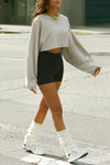 Front view of model posing in the cropped relaxed fit fog cotton slouchy crop long sleeve top with a crew neckline, dropped shoulders and oversized sleeves