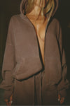 Front view of model posing in the oversized comfortable cedar french terry Oversized Zip Hoodie with a full length front zip closure, side pockets and thumbholes in the fitted cuffs