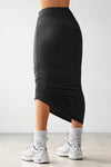 Back view of model from the waist down posing in the midi length black modal Cinched Skirt with adjustable side cinching