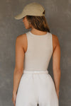 Back view of model posing in the fitted and stretchy dune flexrib High Square Neck Tank top with a high square neckline
