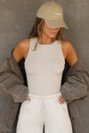 Front view of model posing in the fitted and stretchy dune flexrib High Square Neck Tank top with a high square neckline