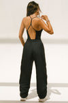 Full body back view of model posing in the fitted black modal Open T-Back Cami with an open t-back design
