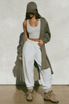 Full body front view of model posing in the knee-length loose fitting moss sherpa Oversized Cardigan with a rolled neckline and extra long sleeves