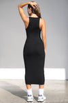 Full body back view of model posing in the sleeveless black flexrib Plunge Tie Midi Dress with a plunging neckline and tie detail at the bust
