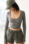 Front view of model posing in the fitted soft ash grey Scoop Neck Long Sleeve top with a deep scoop neckline and fitted sleeves