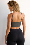 Back view of model posing in the fitted and stretchy mineral flexrib Strappy Crop Tank with thin straps and a low back