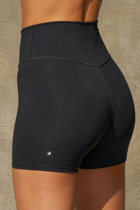 Close up detail back view of model from the waist down posing the soft and stretchy high-waisted sueded onyx 2.5 inch Body Short with a wide waistband and shortened 2.5 inch inseam