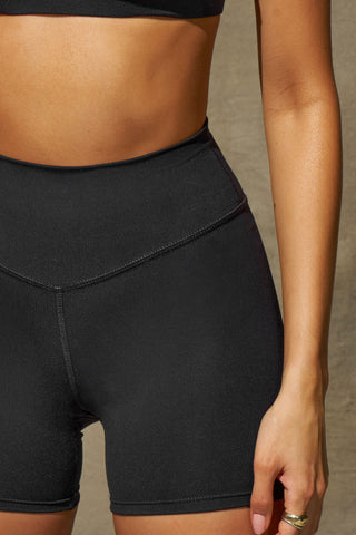 Close up detail front view of model from the waist down posing the soft and stretchy high-waisted sueded onyx 2.5 inch Body Short with a wide waistband and shortened 2.5 inch inseam