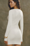 Back view of model posing in the soft and fitted natural luxe knit Asymmetrical Button Mini Dress with long sleeves,  a v-neckline and asymmetrical button-front details. 