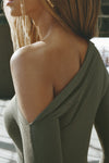 Close up detail side view of model posing in the fitted and lighweight spruce modal Asymmertical Long Sleeve top with an asymmetrical neckline and single-shoulder design
