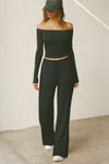 Full body front view of model posing in the fitted, slightly cropped black modal Bare Shoulder Long Sleeve top with a straight, off-the-shoulder neckline