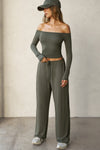 Full body front view of model posing in the fitted, slightly cropped spruce modal Bare Shoulder Long Sleeve top with a straight, off-the-shoulder neckline