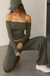 Front view of model posing in the fitted, slightly cropped spruce modal Bare Shoulder Long Sleeve top with a straight, off-the-shoulder neckline