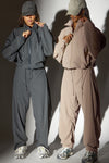 Two models posing in a jet nylon and fawn  nylon Classic Windbreaker Jacket and Barrel Pant sets