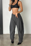Front view of model posing in the oversized, horseshoe-style jet nylon Barrel Pant with side pockets, zip fly, pleated sides and adjustable snap closures at the ankle.