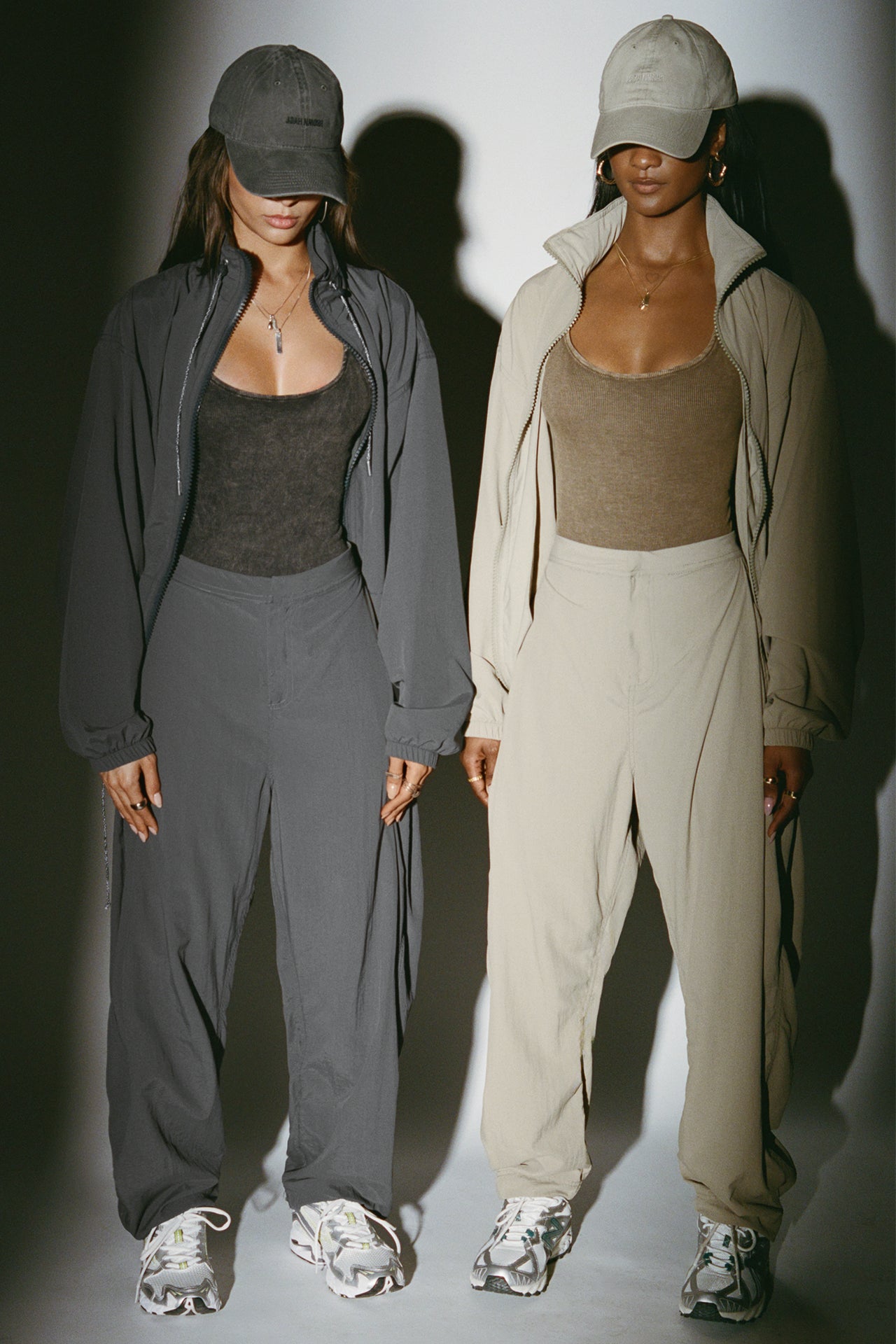 Two models posing in a jet nylon and desert sage nylon Classic Windbreaker Jacket and Barrel Pant sets