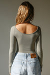 Back view of model posing in the fitted, light weight sage modal Boatneck Long Sleeve with boat neckline and scoop back
