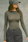 Front view of model posing in the fitted, lightweight spruce modal Boatneck Long Sleeve with a boat neckline