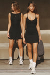 Two models posing in black dresses by Joah Brown