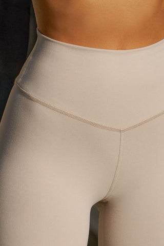 Close up detail front view of model from the waist down posing in the stretch high-waisted sueded yuma 4 Inch Body Short with slimming and contouring wide waistband and 4 inch inseam.