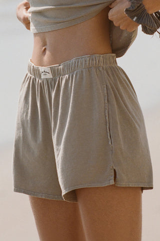 Close up side view of model from the waist down posing in the sage grey classic cotton boxer-inspired Boxer Short in a relaxed silhouette, with an elastic waistband and side pockets.