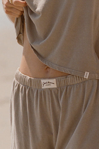 Close up front view of model from the waist down posing in the sage grey classic cotton boxer-inspired Boxer Short in a relaxed silhouette, with an elastic waistband and side pockets.