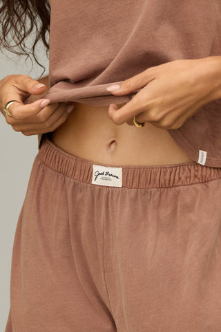 Close up front view of model from the waist down posing in the tobacco classic cotton boxer-inspired Boxer Short in a relaxed silhouette, with an elastic waistband and side pockets.