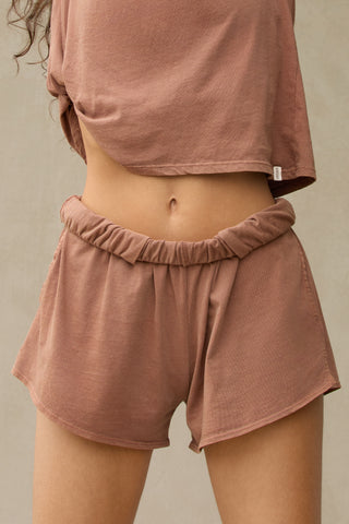 Close up front view of model from the waist down posing in the tobacco classic cotton boxer-inspired Boxer Short in a relaxed silhouette, with an elastic waistband and side pockets.